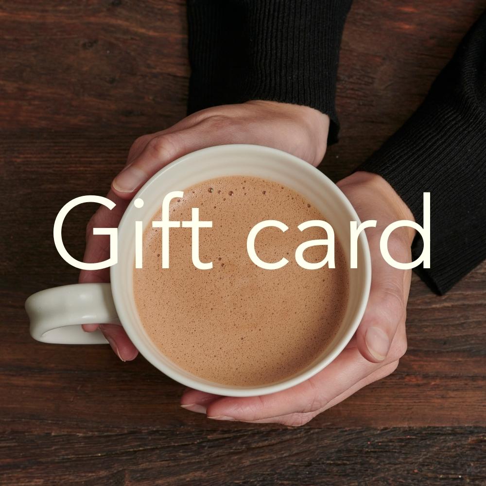 A person holding a cup of chocolate drink with the text 'Gift card' placed over the top.