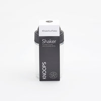 A packaged hot chocolate shaker by KNOOPS, with branding and product information visible on the box.